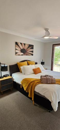 a large bedroom with a large bed with yellow pillows at Serendipity On Barrington in Barrington