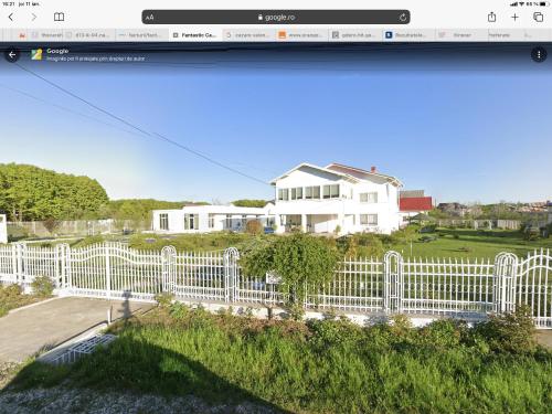 a website screenshot of a white fence in front of a house at Fantastic camp in Piteşti
