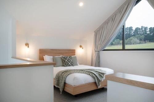 1 dormitorio con cama y ventana grande en Koze Haus - Blissful Barn by the River, en Hillwood