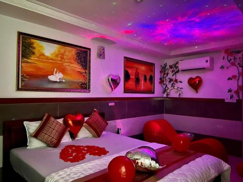a bedroom with a bed with red hearts on the wall at Gia Hân Hotel in Ho Chi Minh City