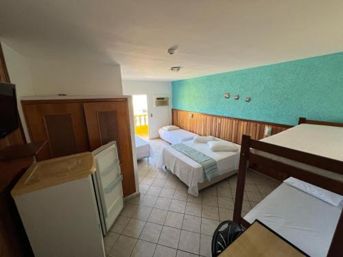 een slaapkamer met 2 bedden en een blauwe muur bij Pousada Martin de Sá in Caraguatatuba