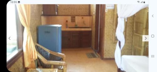 una pequeña cocina con nevera azul en una habitación en Kalinka Inn, en Gili Meno