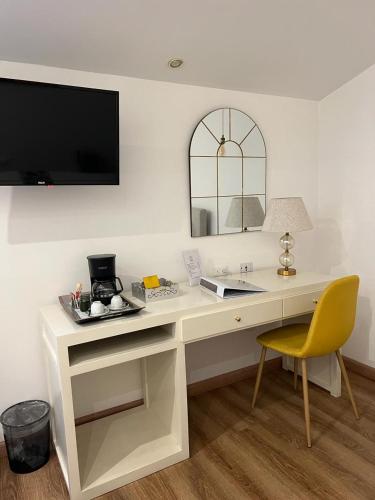 a white desk with a yellow chair in a room at Adamas House Hotel Boutique in Quito