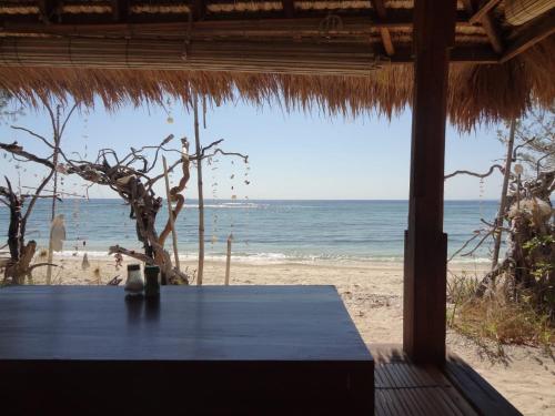 a table on a beach with a view of the ocean at Kalinka Inn in Gili Meno