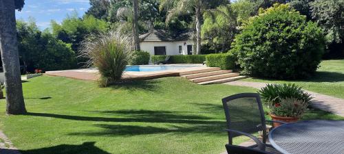 un patio con piscina y una casa en HERMOSA CASA EN BARRIO CERRADO, A 30 KM DE LA CIUDAD DE BUENOS AIRES Y 10 KM. DEL AEROPUERTO INTERNACIONAL DE EZEIZA en Ezeiza