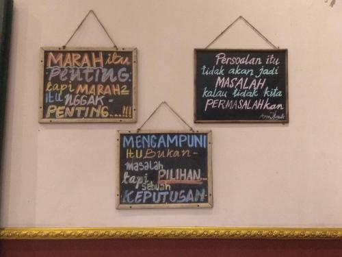 a group of signs hanging on a wall at Guest house TBE C9 in Tambakaji