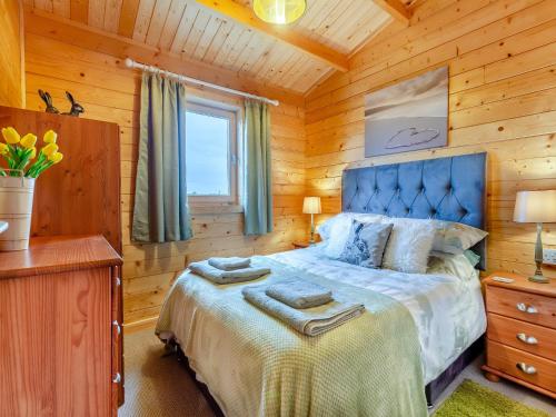 a bedroom with a bed in a log cabin at Seashell Lodge in Gairloch