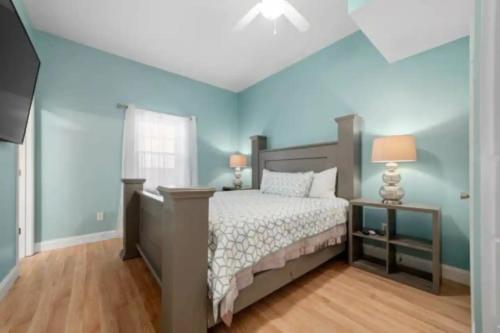 a bedroom with a bed and a blue wall at Sunset Cove Lakefront Luxury Lodge with Private Dock in Dandridge