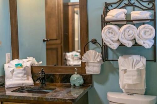 a bathroom with a sink and a mirror and towels at Sunset Cove Lakefront Luxury Lodge with Private Dock in Dandridge