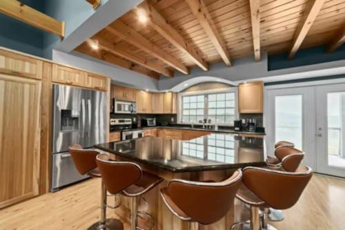 a kitchen with a large island with leather chairs at Sunset Cove Lakefront Luxury Lodge with Private Dock in Dandridge