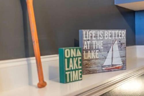 a shelf with two books and a sailboat on it at Sunset Cove Lakefront Luxury Lodge with Private Dock in Dandridge