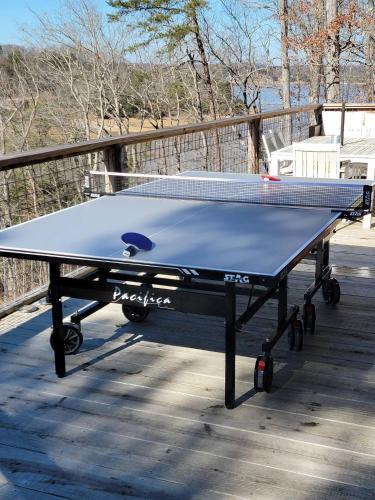 a ping pong table sitting on top of a deck at Sunset Cove Lakefront Luxury Lodge with Private Dock in Dandridge