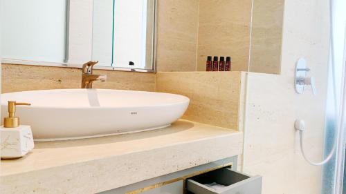 a bathroom with a white sink on a counter at Art Deco Luxury Hotel & Residence in Bandung