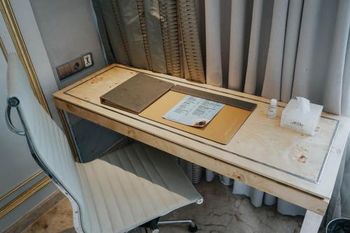 a desk in a room with a book on it at Art Deco Luxury Hotel & Residence in Bandung