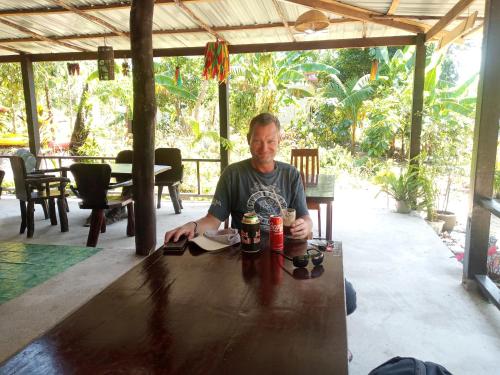 喀比的住宿－Bangkaew Camping place bangalow，坐在桌子上喝两杯饮料的人