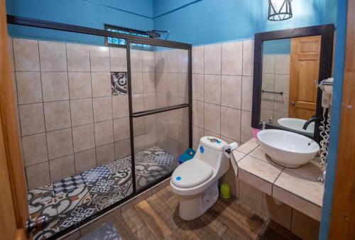 a bathroom with a shower and a toilet and a sink at Casa Encanto in Puntarenas