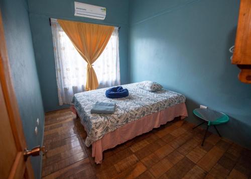 a bedroom with a bed and a window at Casa Encanto in Puntarenas