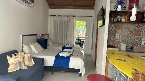 Habitación con 2 camas y sofá. en Flat temático Solar Água, en Pipa