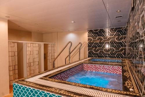 baño con bañera de hidromasaje y pared de mosaico en Diamond Hotel, en Hai Phong