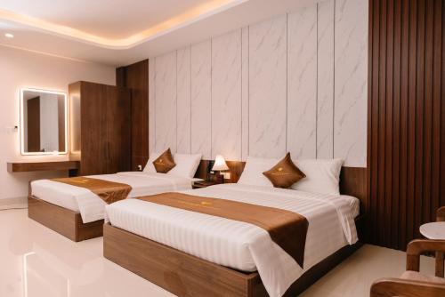 a hotel room with two beds and a television at Diamond Hotel in Hai Phong