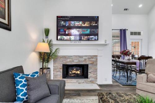 a living room with a fireplace with a tv above it at Frisco Resort Style Home w/Spa in Frisco