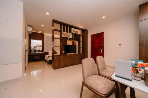 a living room with two chairs and a table and a television at Diamond Hotel in Hai Phong