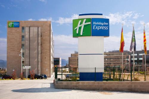 a sign in front of a building with flags at Holiday Inn Express Sant Cugat by IHG in Sant Cugat del Vallès
