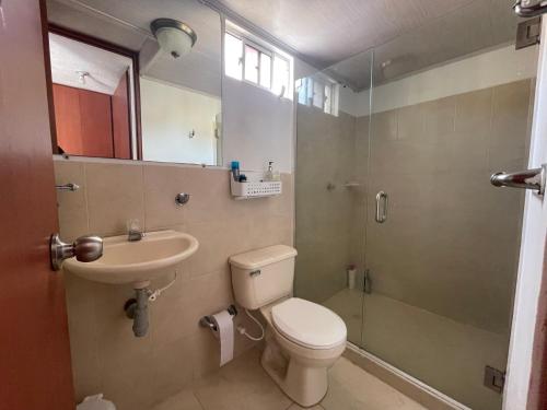 een badkamer met een toilet, een wastafel en een douche bij Cómodo paramento zona norte in Barranquilla