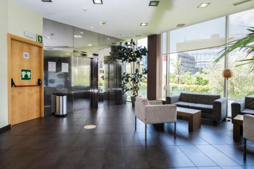 a lobby with couches and chairs in a building at Holiday Inn Express Sant Cugat by IHG in Sant Cugat del Vallès