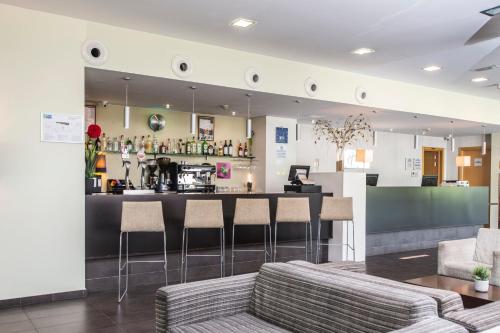 a bar with stools and a counter in a room at Holiday Inn Express Sant Cugat by IHG in Sant Cugat del Vallès