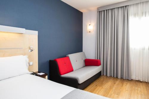 a hotel room with a bed and a chair and a window at Holiday Inn Express Sant Cugat by IHG in Sant Cugat del Vallès