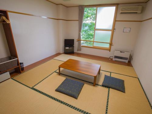 a living room with a coffee table and a window at Sun R in Rokugō