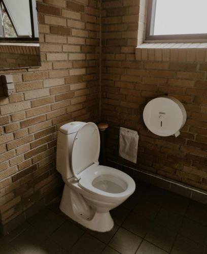 La salle de bains est pourvue de toilettes et d'un mur en briques. dans l'établissement Tarm camping, à Tarm