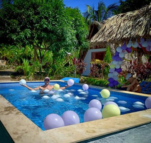 a man in a swimming pool with balls in it at ECO-Hotel Amanecer Tayrona dentro del parque tayrona in El Zaino