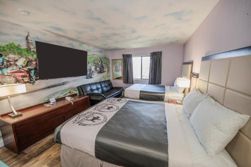 a hotel room with two beds and a flat screen tv at RIVER OAK INN in Bandera