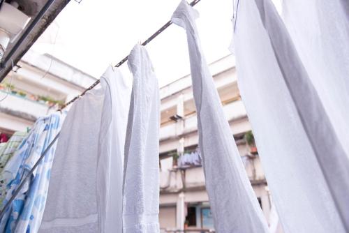 um monte de toalhas brancas penduradas numa linha de roupas em Ah Shan Hostel em Hong Kong