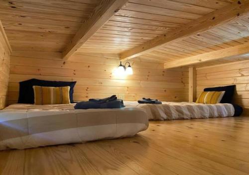 - 2 lits dans une chambre dotée de murs en bois dans l'établissement Serene 1BR Cabin near NC Z00 with Loft & Waterview, à Asheboro