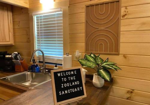 a sign sitting on a counter in a kitchen at Serene 1BR Cabin near NC Z00 with Loft & Waterview in Asheboro