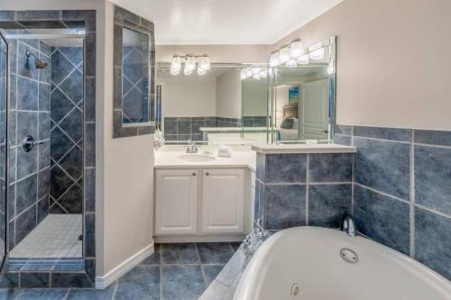 a bathroom with a tub and a shower and a sink at Holiday Inn Club Vacations Panama City Beach Resort in Panama City Beach