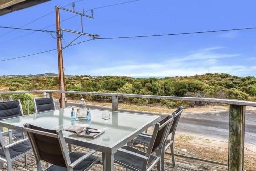 a table and chairs on a balcony with a view of the beach at LONGUSTINE - Pet Friendly in Robe