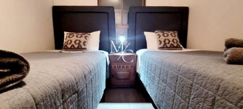 una habitación con 2 camas y una luz entre ellas en MC SUITE NORTE - 100 MT² - 3 HABITACIONES en Antofagasta