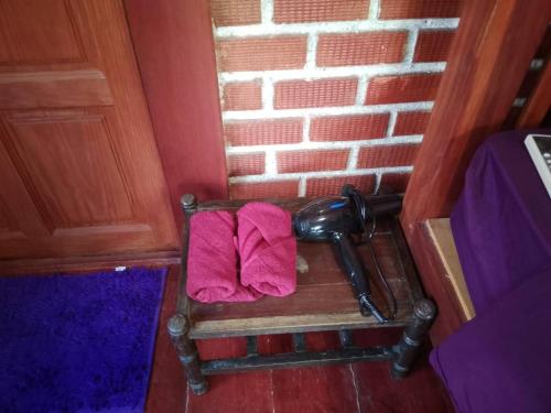 a wooden bench with a pink towel on it at Lanta Yoky bangalow in Phra Ae beach