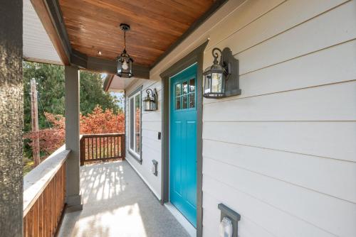 a house with a blue door on a porch at Vi Cottage in North Saanich