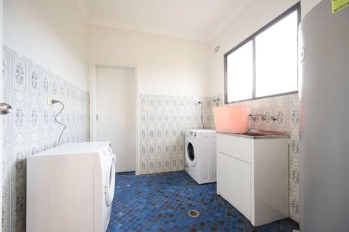 a bathroom with a washing machine and a washer and dryer at Modern and Spacious 5-Bedroom House in Liverpool in Liverpool