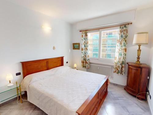 une chambre avec un grand lit et une fenêtre dans l'établissement 3P climatisé avec balcon près plages, commerces, WiFi et animaux admis - FR-1-196-349, à Menton