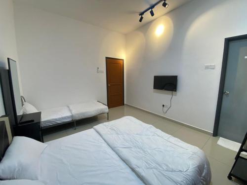 a bedroom with two beds and a tv on the wall at KSP Guest House in Melaka