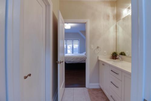 een badkamer met een wastafel, een spiegel en een bed bij Luxury house In Scarborough in Toronto