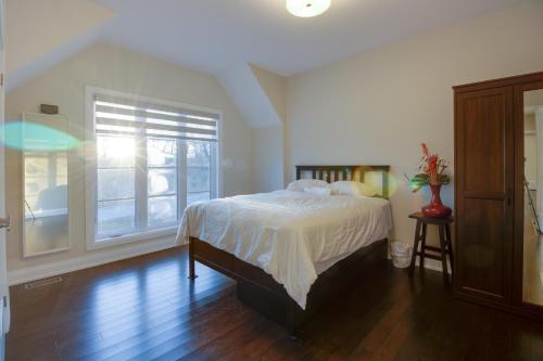 een slaapkamer met een bed en een groot raam bij Luxury house In Scarborough in Toronto
