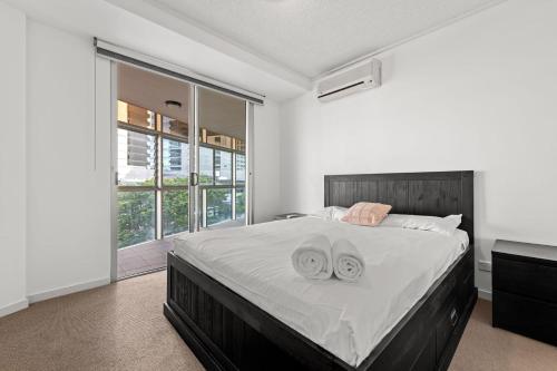 ブリスベンにあるToulouse Apartments Fortitude Valleyのベッドルーム1室(大型ベッド1台、タオル2枚付)