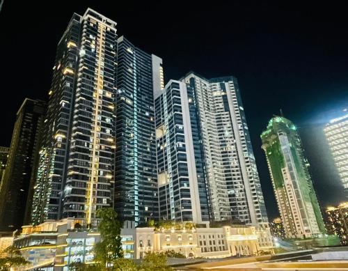 a group of tall buildings in a city at night at Uptown Parksuites BGC in Manila